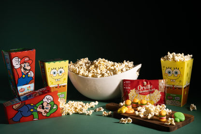 mario and spongebob sqaurepants gift sets staged with popcorn and gummies unqrapped around a bowl of popped popcorn