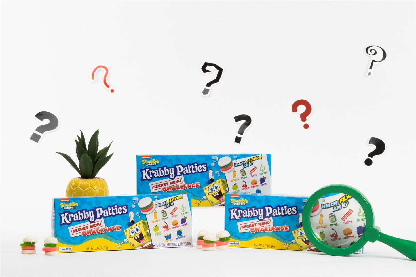 boxes and unwrapped gummies with decorative pineapple and magnifying glass