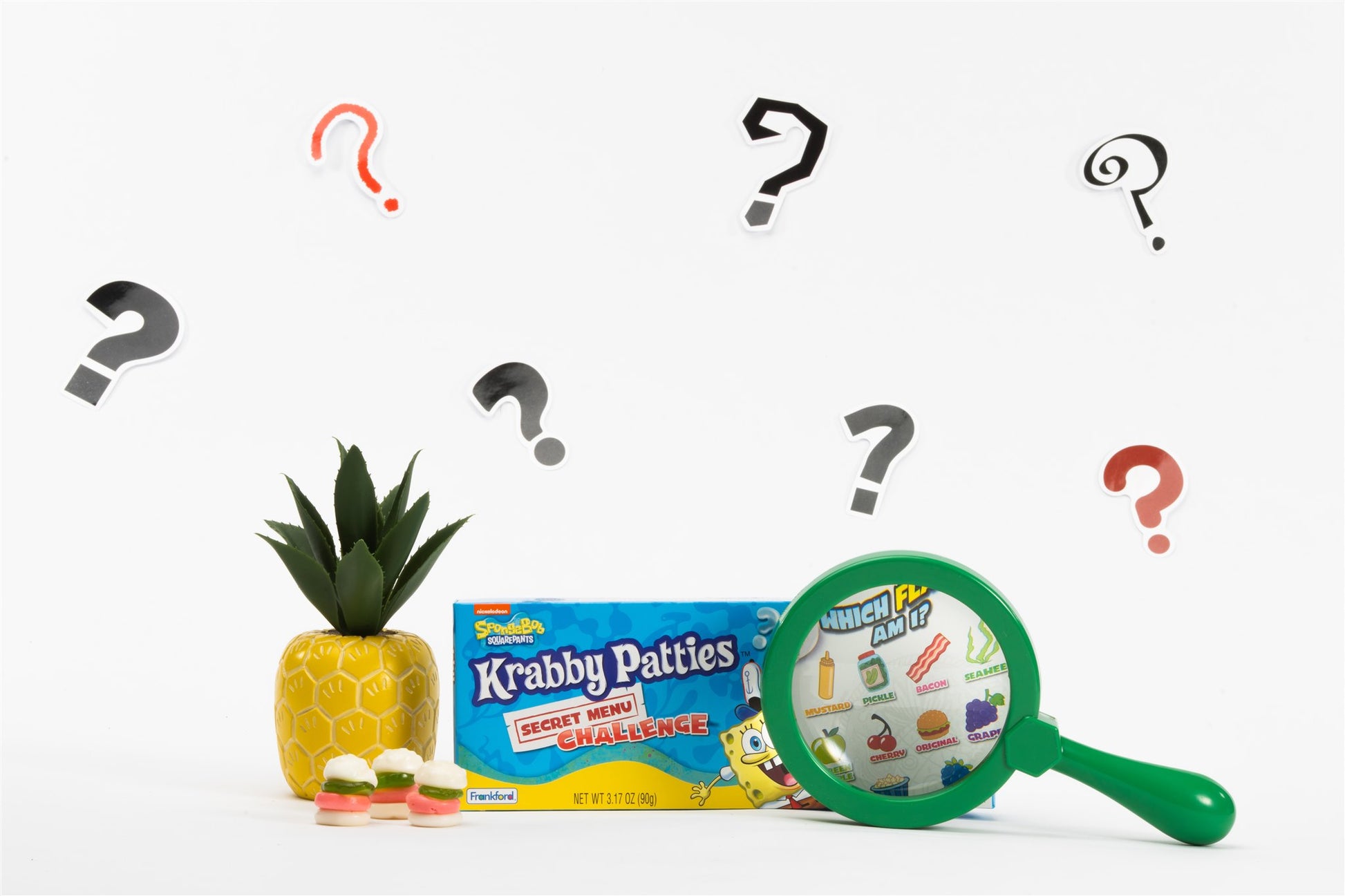 Singular box and unwrapped gummies with decoartive pineapple and magnifying glass 